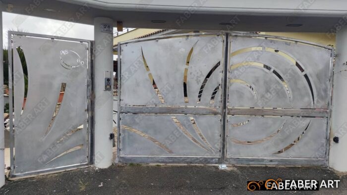 Cancello carrabile a due ante e portoncino pedonale in ferro sagomato al plasma