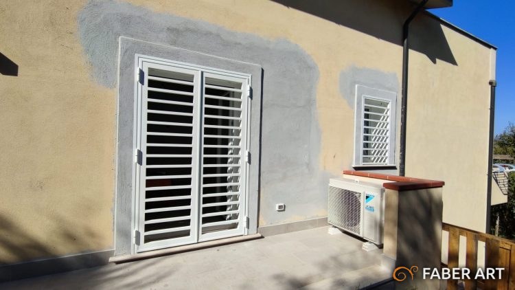 Grata di sicurezza e persiana in ferro verniciato bianco installate su porta finestra.