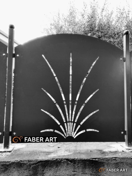 Pannello in lamiera sagomata con intaglio decorativo a raggiera tra montanti in ferro.